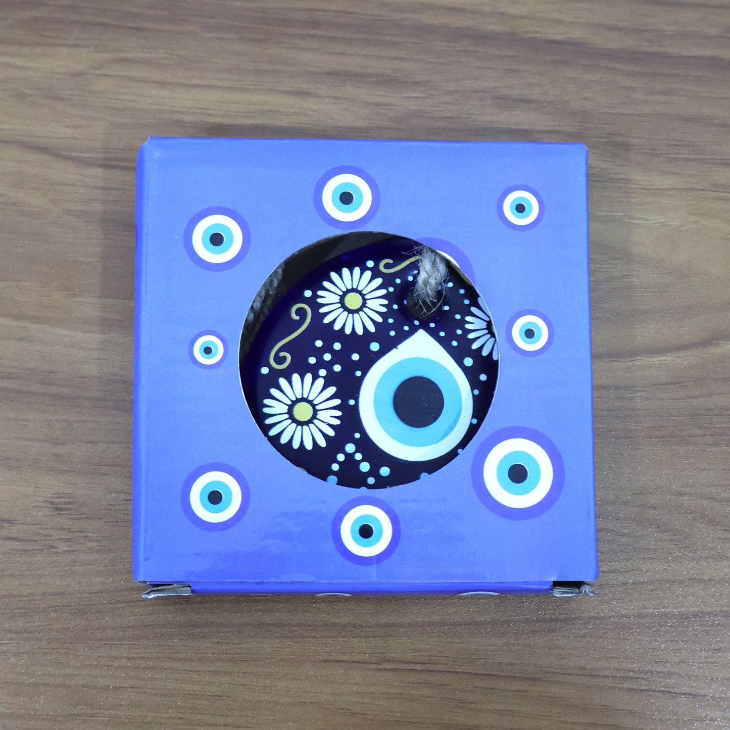 Evil Eye Wall Hanging displayed against rustic wooden background emphasizing cultural charm