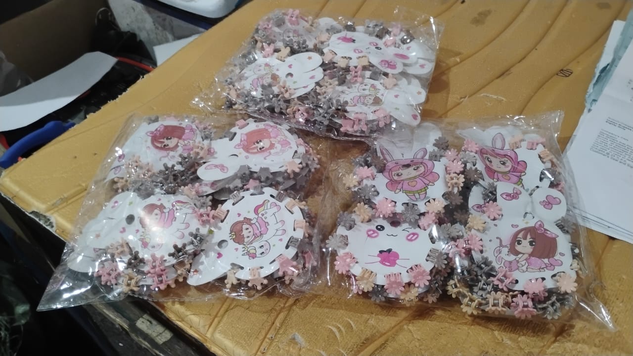 Hand holding multiple pastel-colored mini claw hair clips shaped as bears.