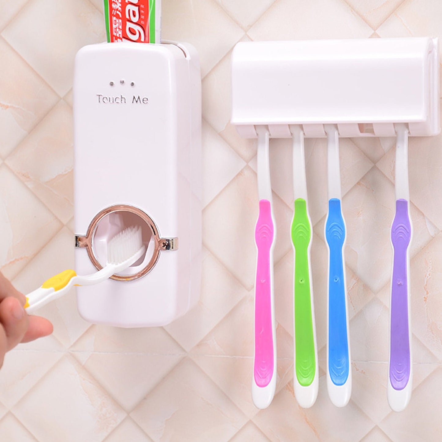 A hand holds a yellow toothbrush to the dispenser, with four other toothbrushes hanging in the holder.