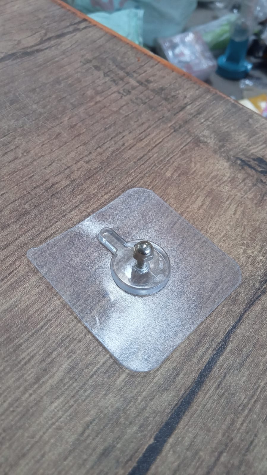 Simple wall hook with a clear adhesive base, ready for quick installation.