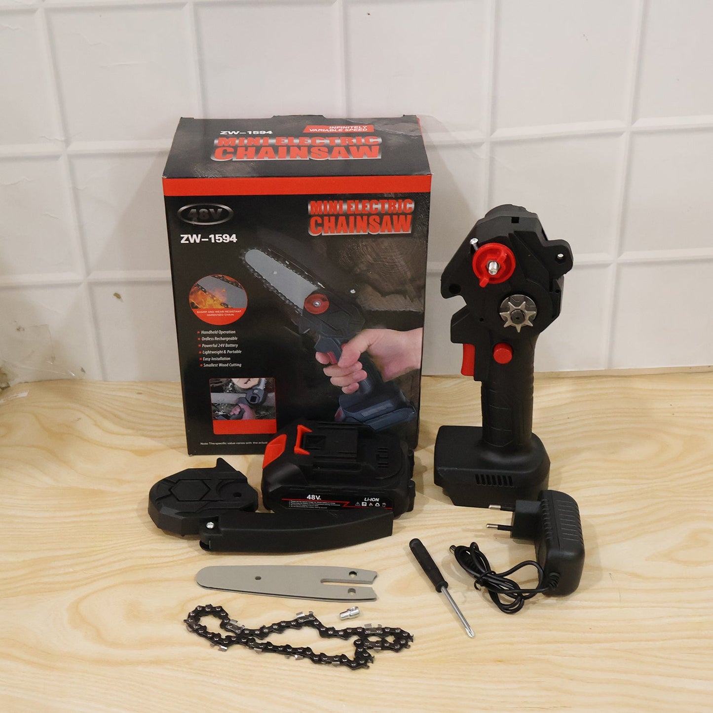 Black and red mini chainsaw with a 48V battery, cutting a tree branch outdoors.