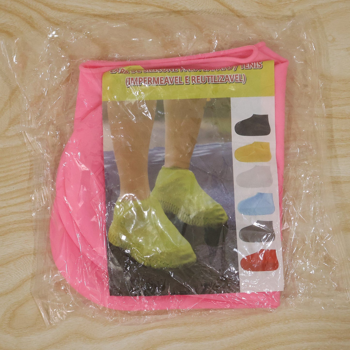 A packaged pair of pink silicone shoe covers is visible through clear plastic, with a label showing people wearing various