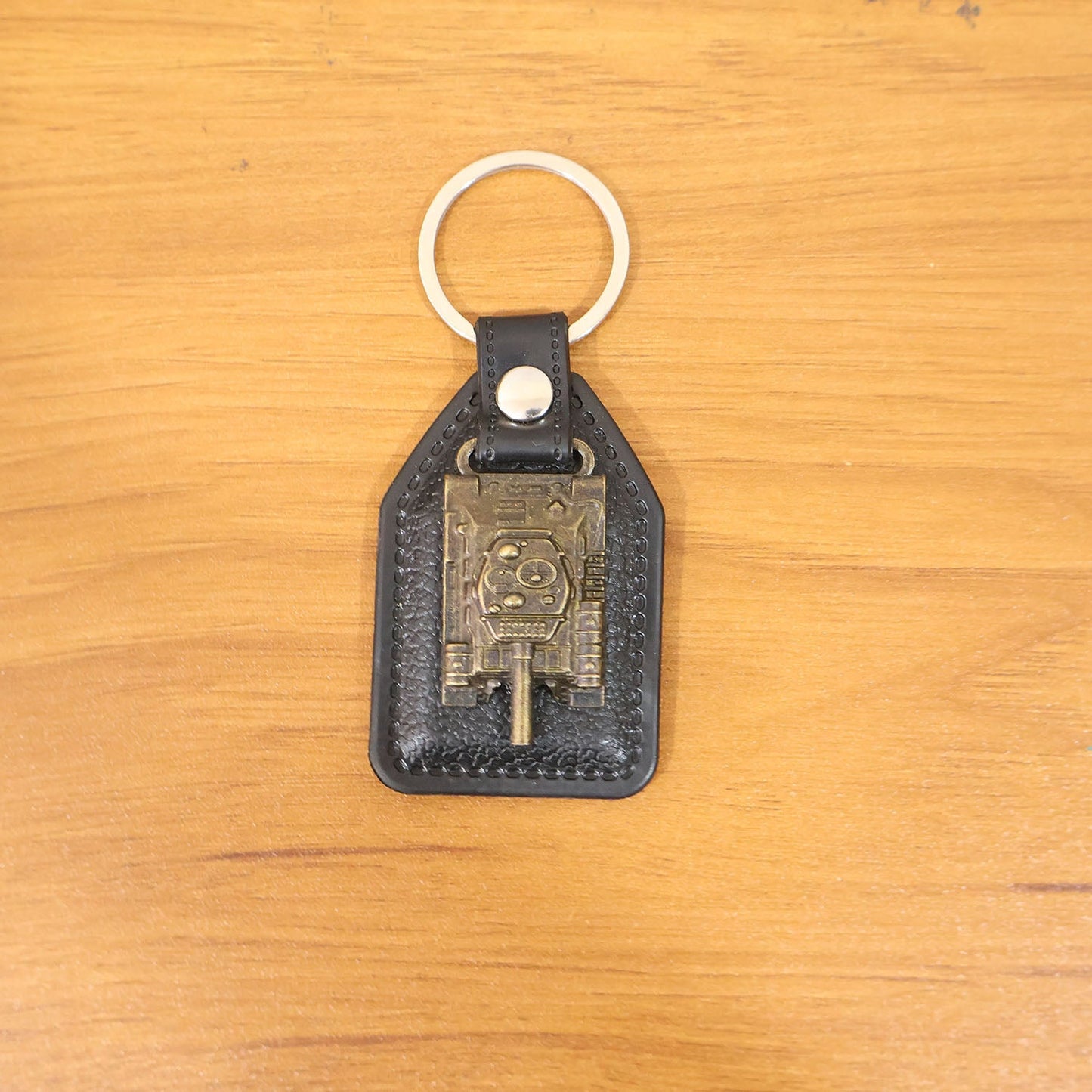 Lifestyle image showing leather finish military tank keychain in daily use