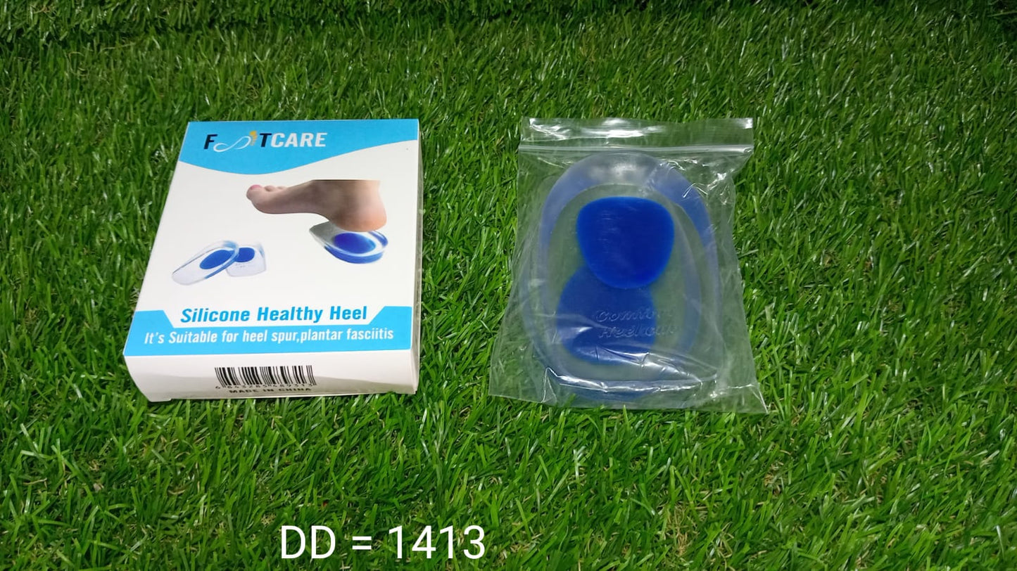 A white and blue box for "FOOTCARE Silicone Healthy Heel" and a clear plastic bag containing gel heel cups rest on green