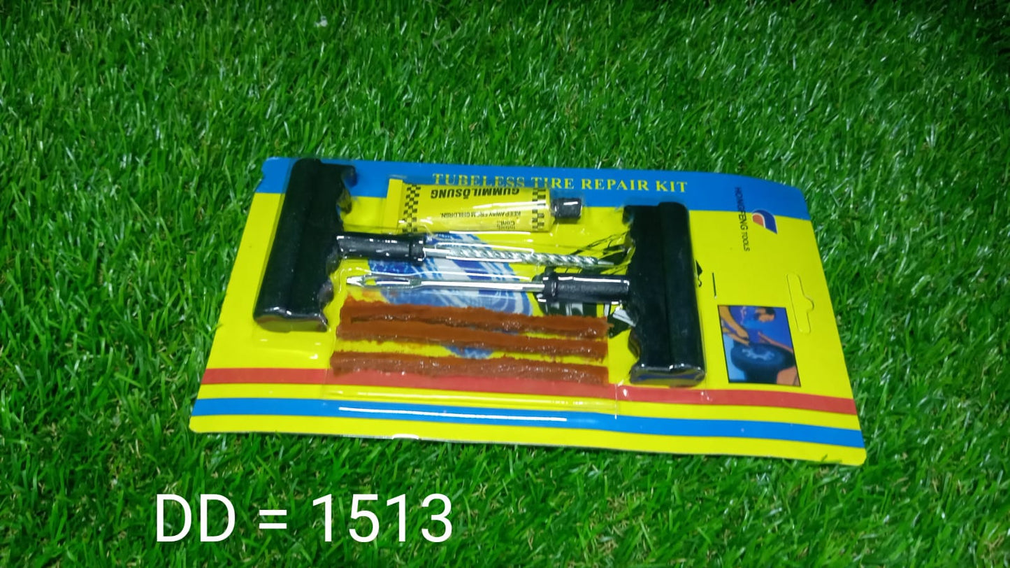 A packaged tubeless tire repair kit on a green grassy surface, showing the tools, strips, and glue.