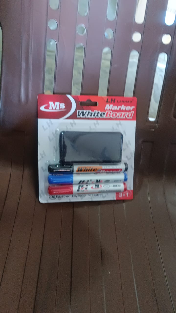 A packaged whiteboard marker set with three markers and a duster, resting on a brown slatted chair.