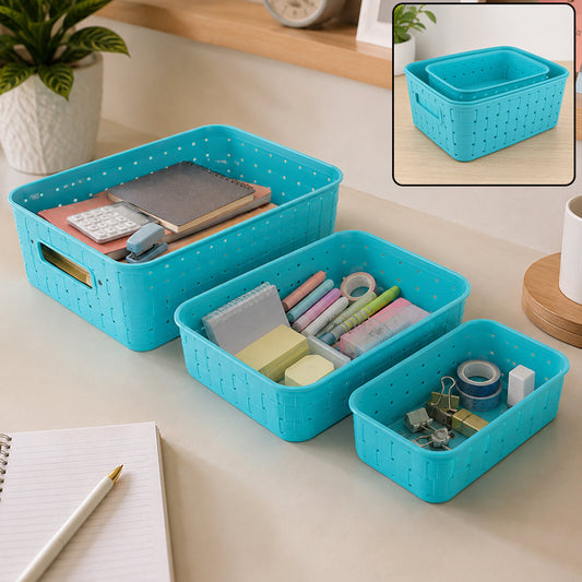 Three sky blue plastic storage baskets of different sizes filled with office supplies on a desk.
