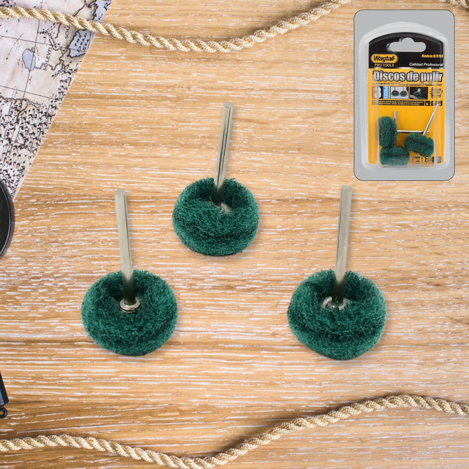 Three green polishing wheels with metal shanks on a wooden background with a rope border and product packaging in the top