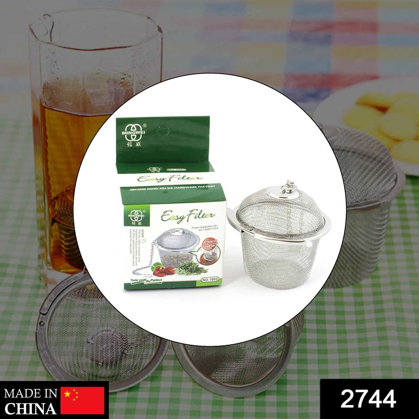 A product image showing a stainless steel tea infuser with its green packaging box and other tea infusers in the background.