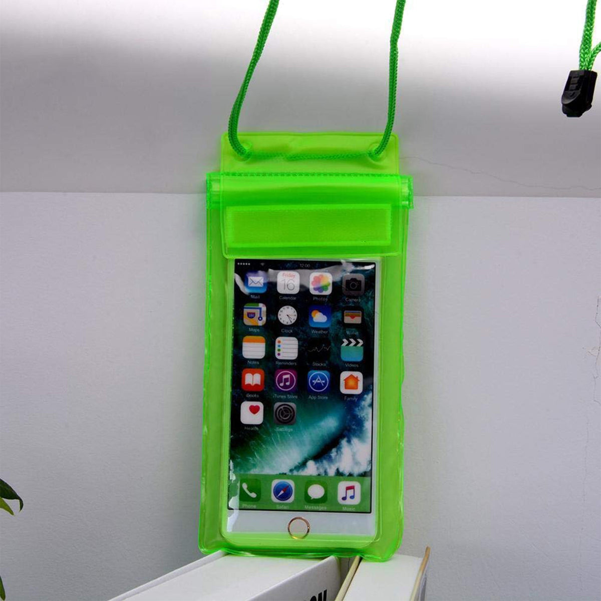 A lime green waterproof phone pouch holds a smartphone displaying app icons, hanging against a white wall with a green