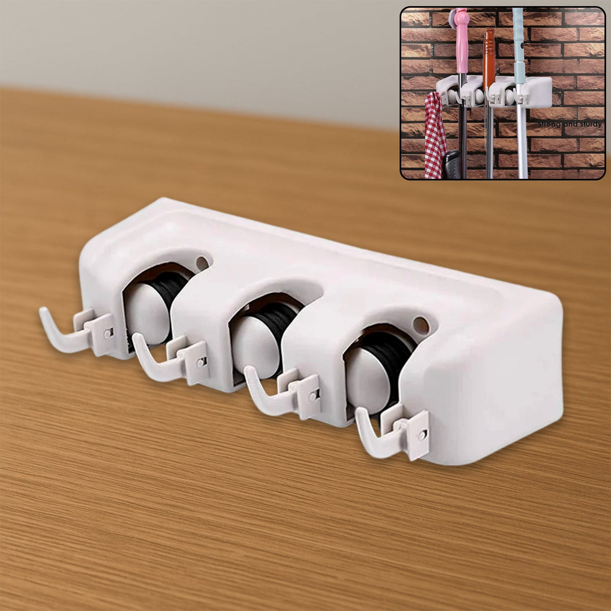 White three-slot wall-mounted mop and broom holder on a wooden surface, with an inset image of it holding cleaning tools on