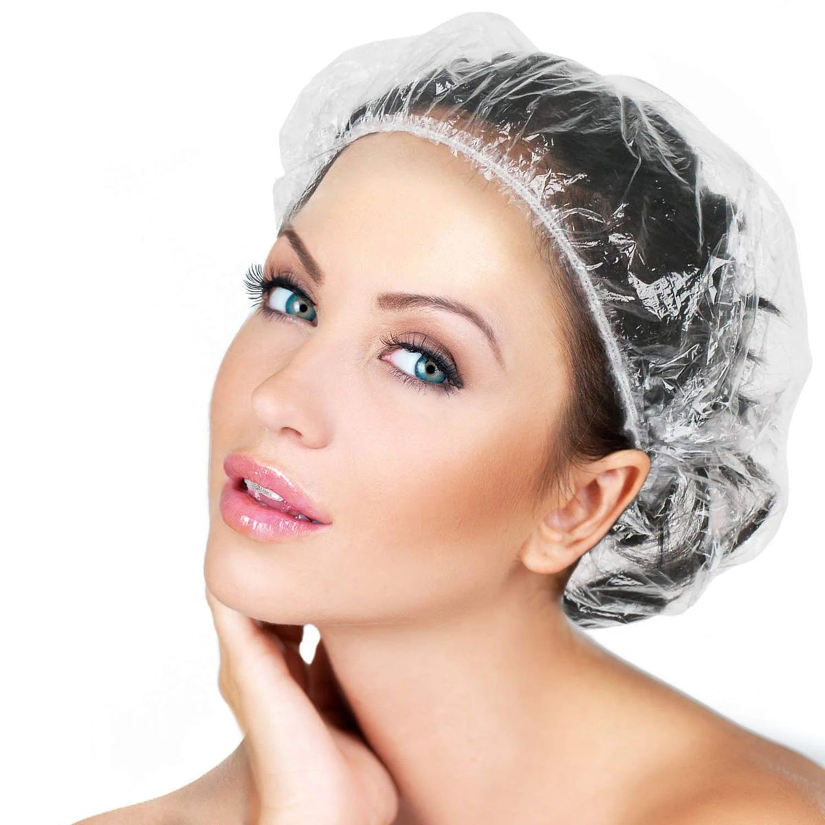 A woman with blue eyes and light makeup wears a clear disposable shower cap, looking directly at the viewer.