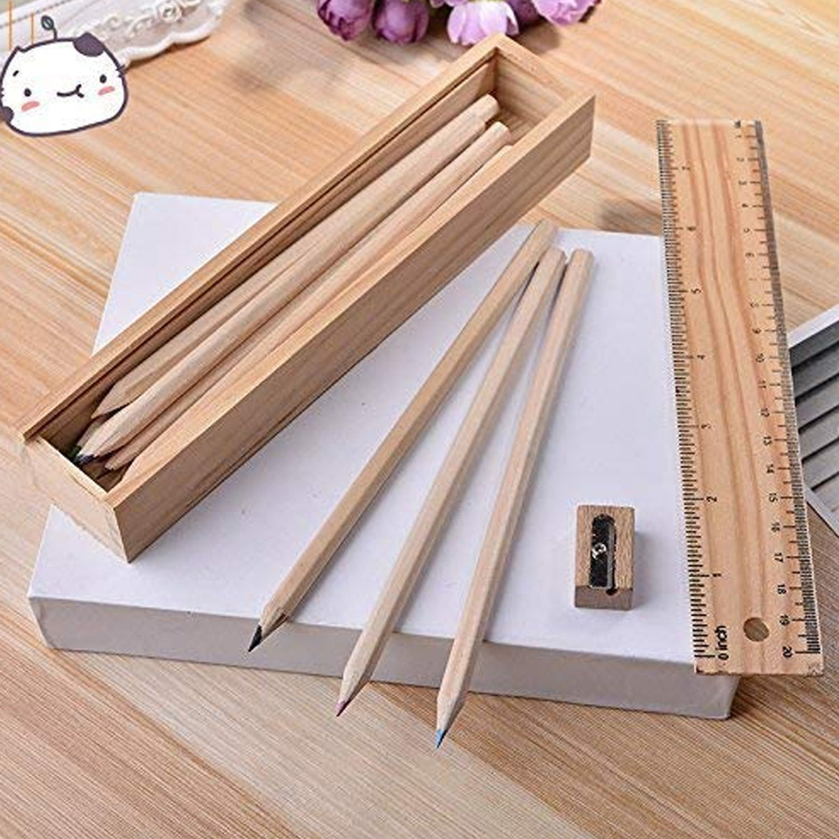 Colourful wooden colored pencils arranged with the sharpener and ruler on a clean background.