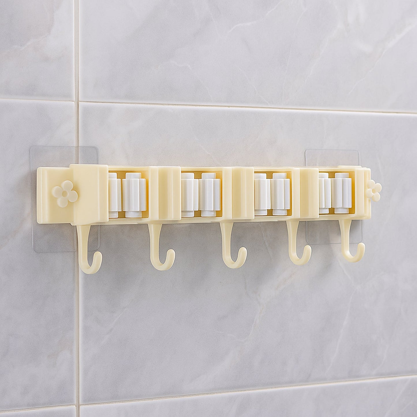 Self-adhesive broom and mop holder rack mounted on wall with utility hooks