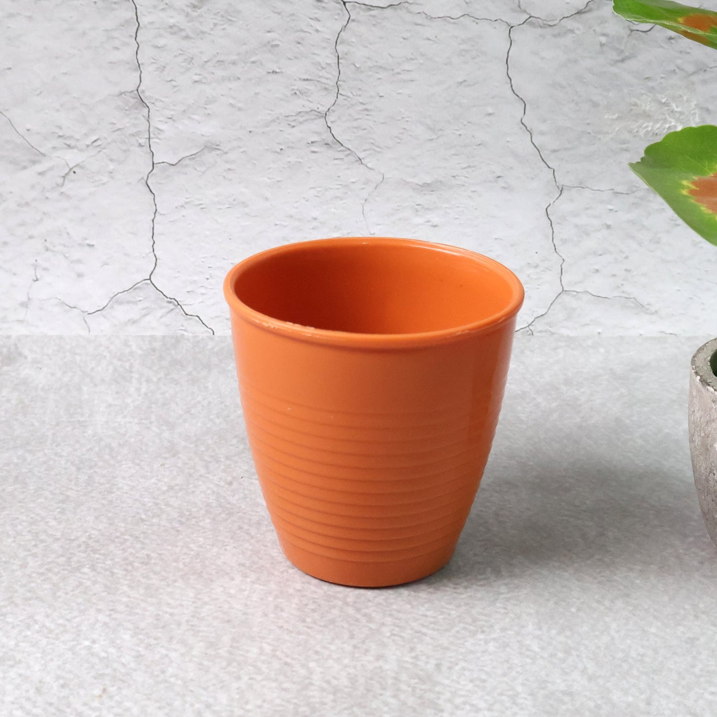 Plastic small drinking glass filled with hot tea on table