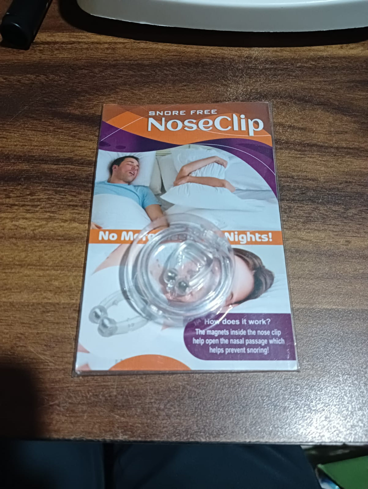 Clear silicone magnetic anti-snore nose clip on a white background.
