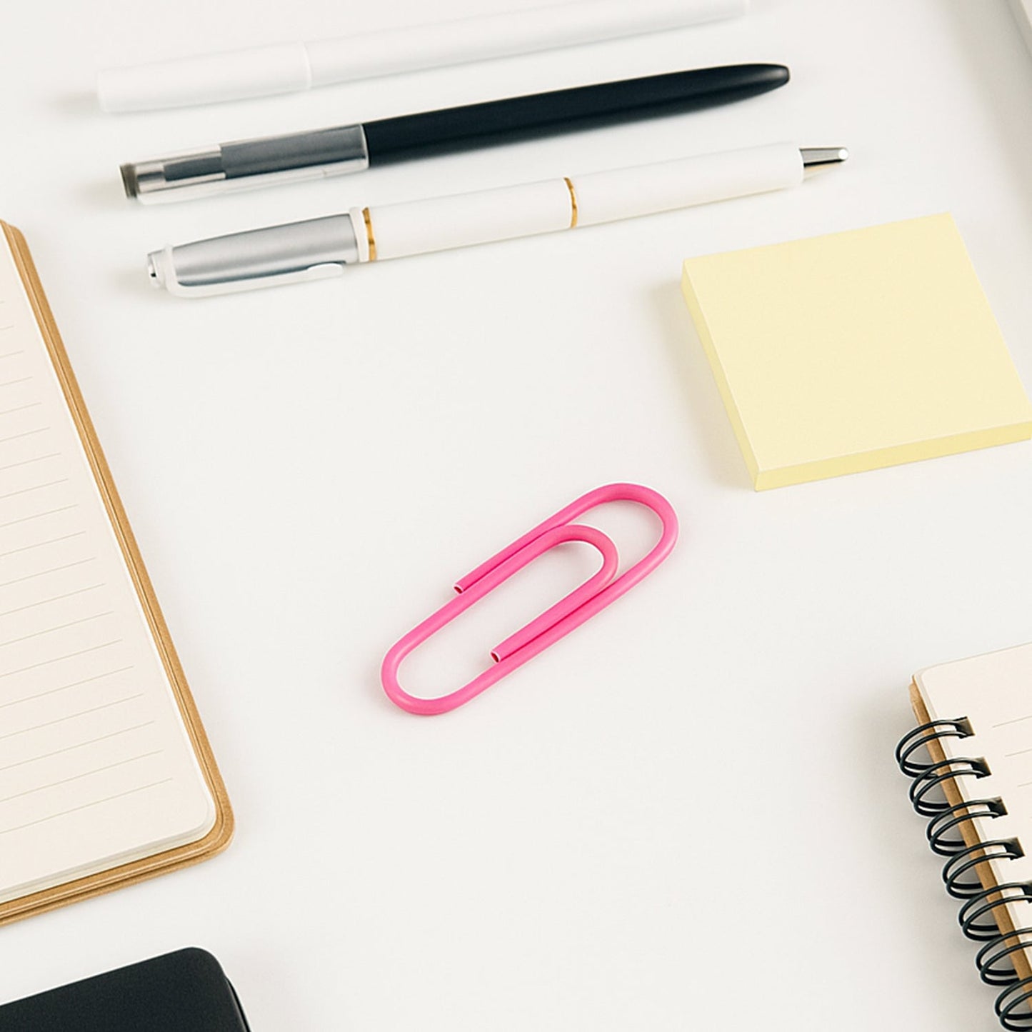 Assorted colourful vinyl-coated paper clips neatly arranged on a clean white background.