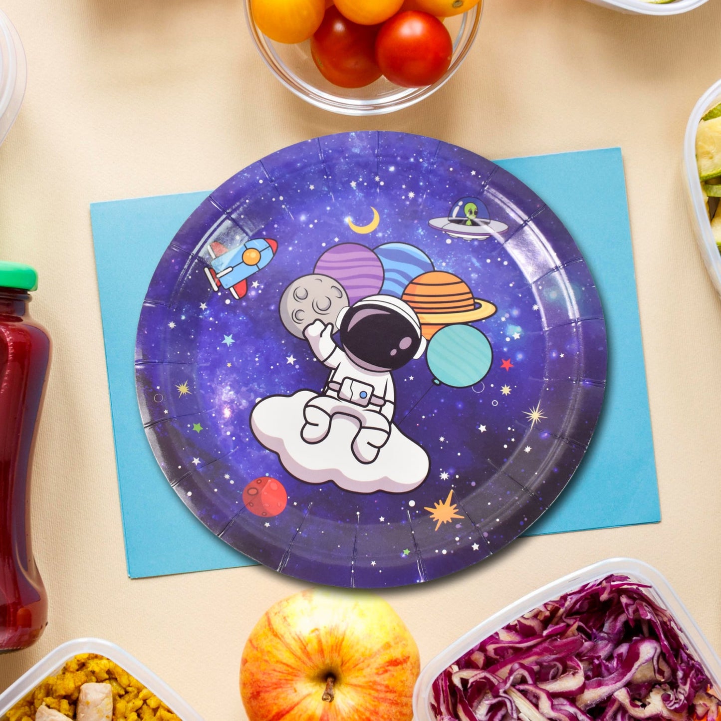A single purple paper plate with an astronaut and planets design, placed on a blue napkin with food items.