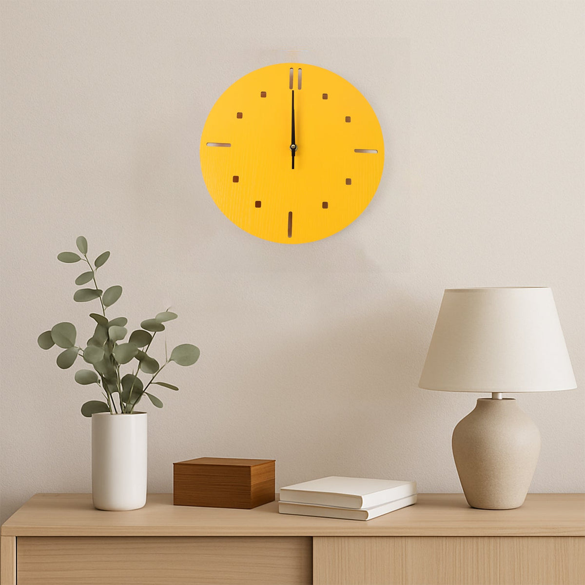 A yellow round wall clock hangs above a wooden console table with a plant, a wooden box, and a lamp.
