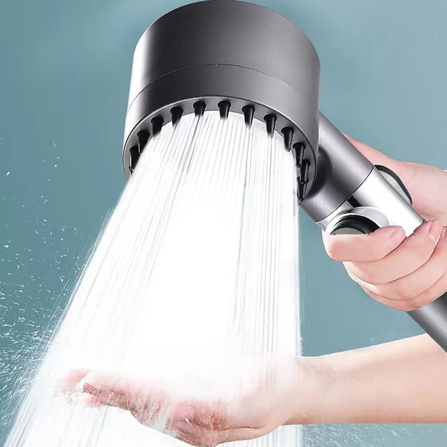 A hand holding the dark gray shower head, with water spraying into an open palm.
