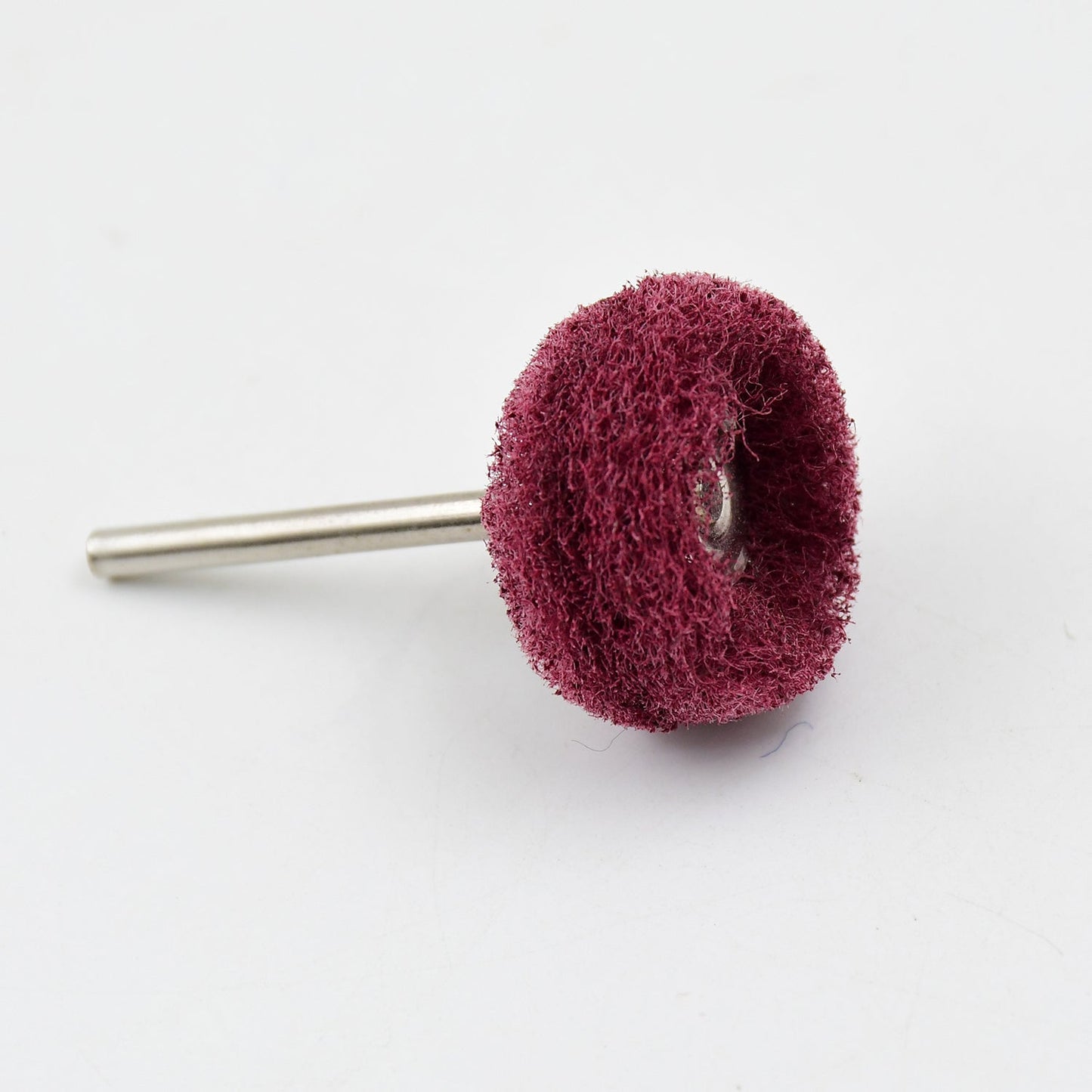 A single maroon buffing wheel with a silver shaft on a white background.