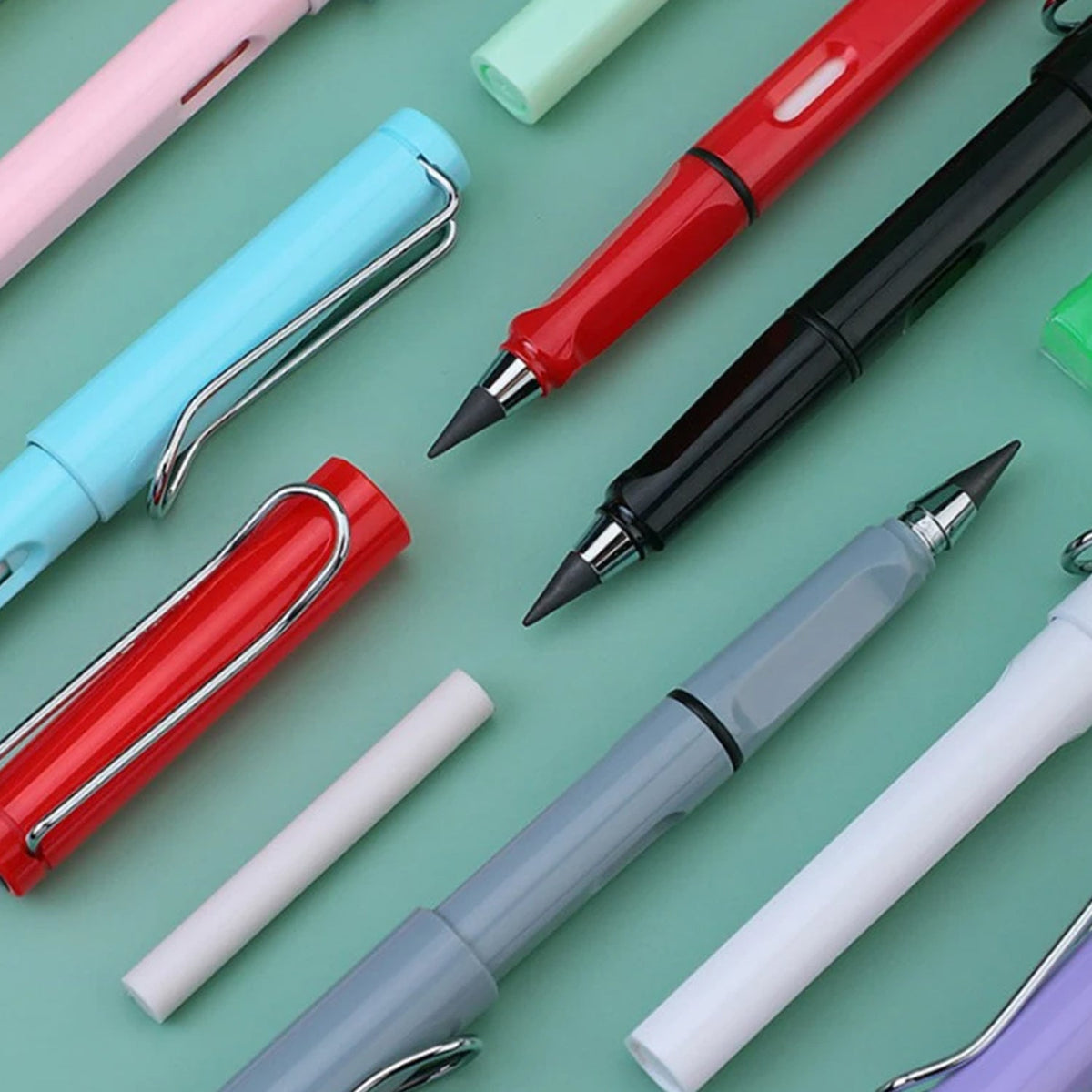 A close-up view of several colorful inkless pencils and an eraser stick on a teal surface.