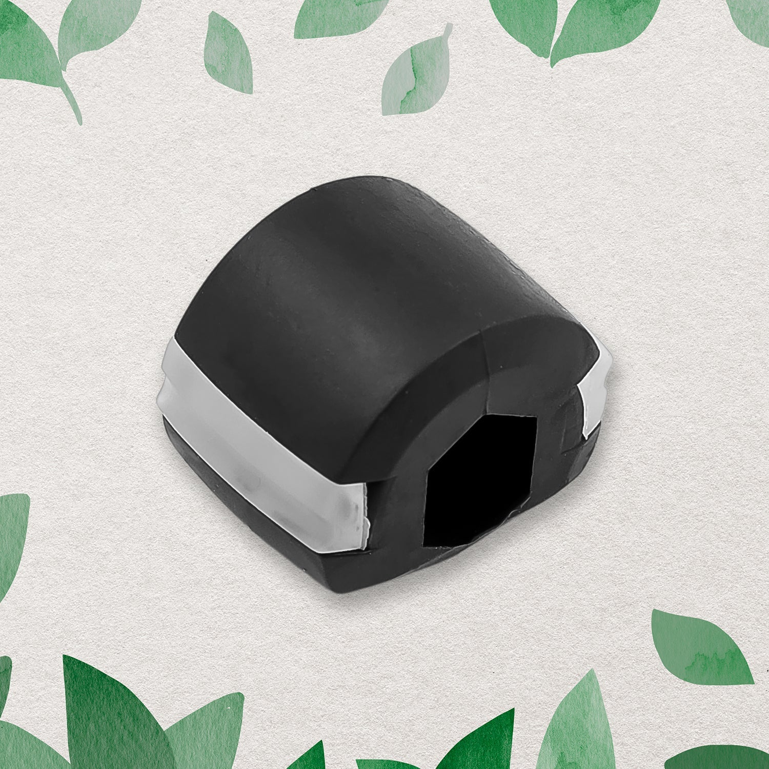 A black and white jaw exerciser centered on a textured white background with green leaves around the edges.