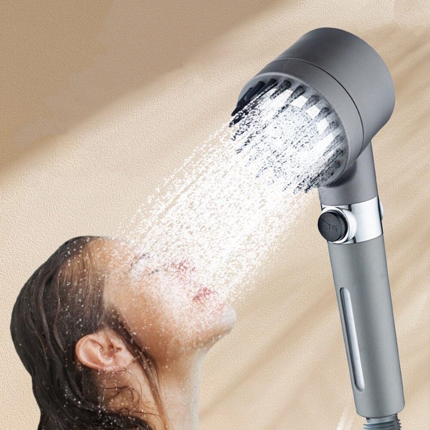 A woman showering with the dark gray shower head, water spraying onto her face.