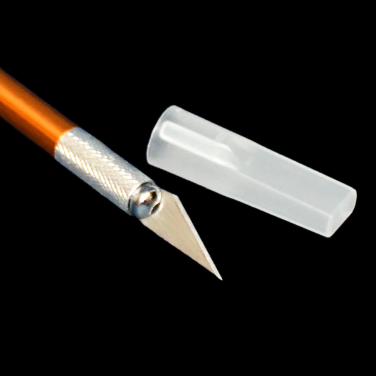 Close-up of the orange precision knife blade and silver grip with its clear protective cap.