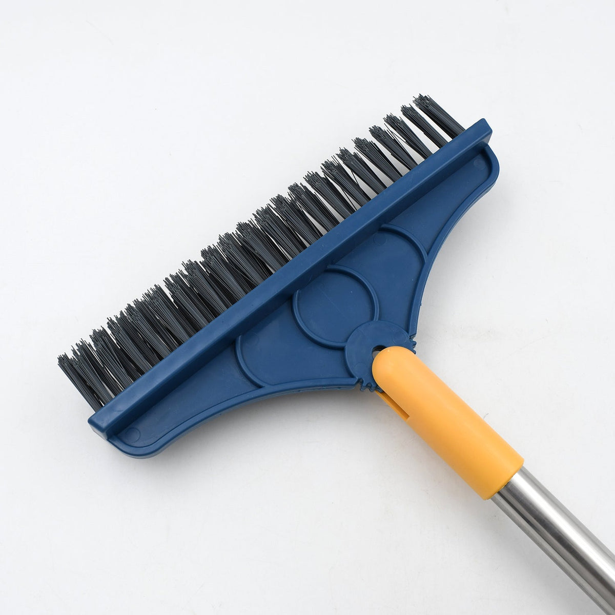 Close-up of the blue brush head with black bristles and yellow squeegee, attached to a silver handle.