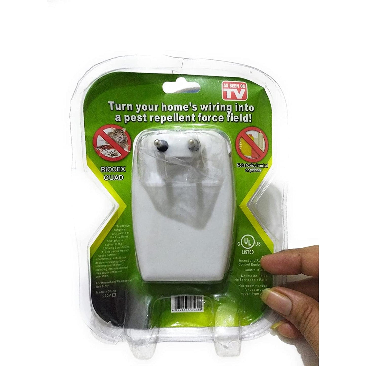 A hand holds the clear plastic packaging of a white pest repeller, showing the two-pronged plug on the back.