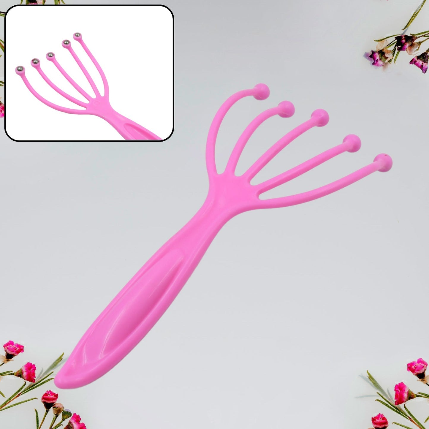 A pink plastic scalp massager with five flexible arms ending in rounded pink tips, with an inset showing a similar massager