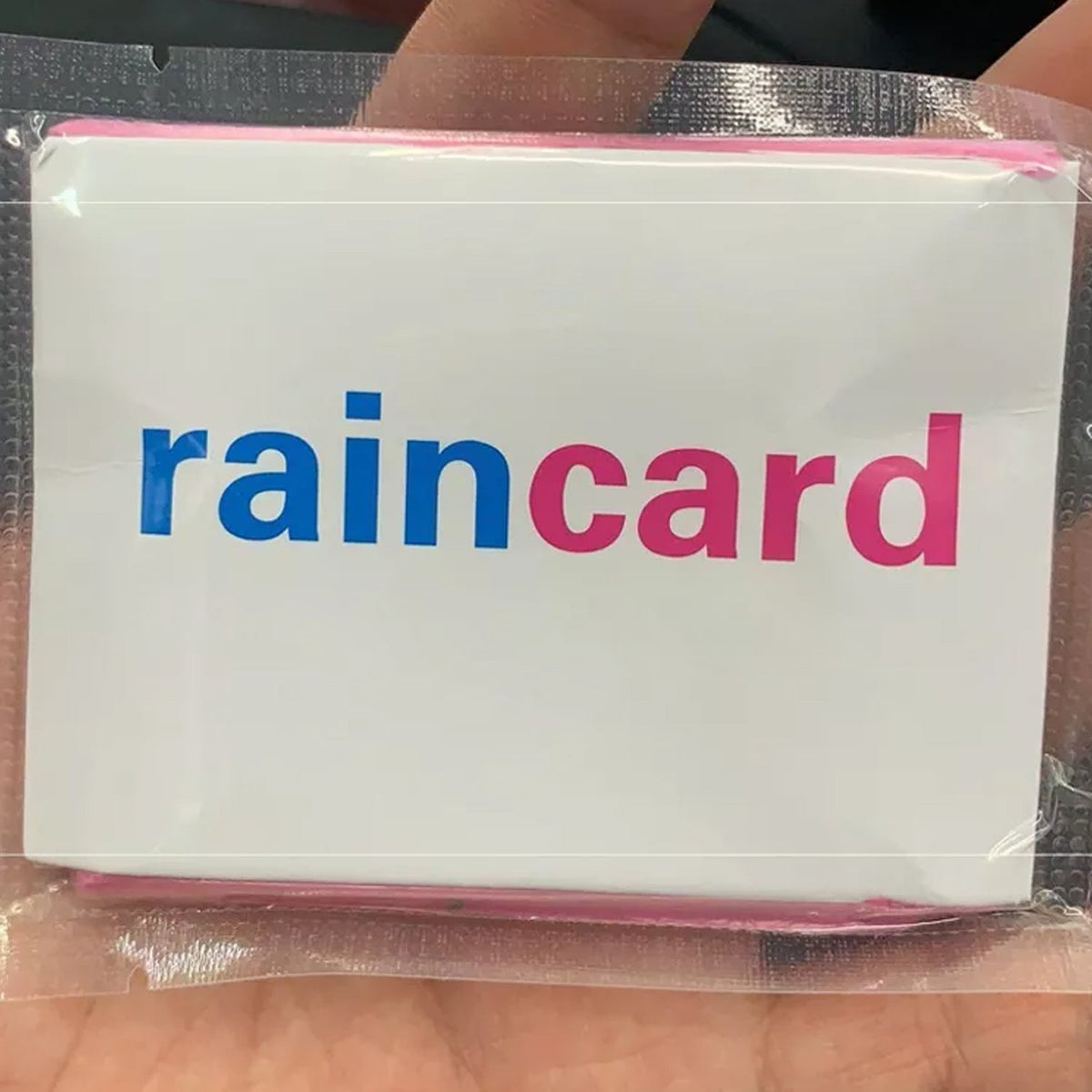 A hand holding a 'raincard' in a clear plastic sleeve, showing the blue and pink logo.
