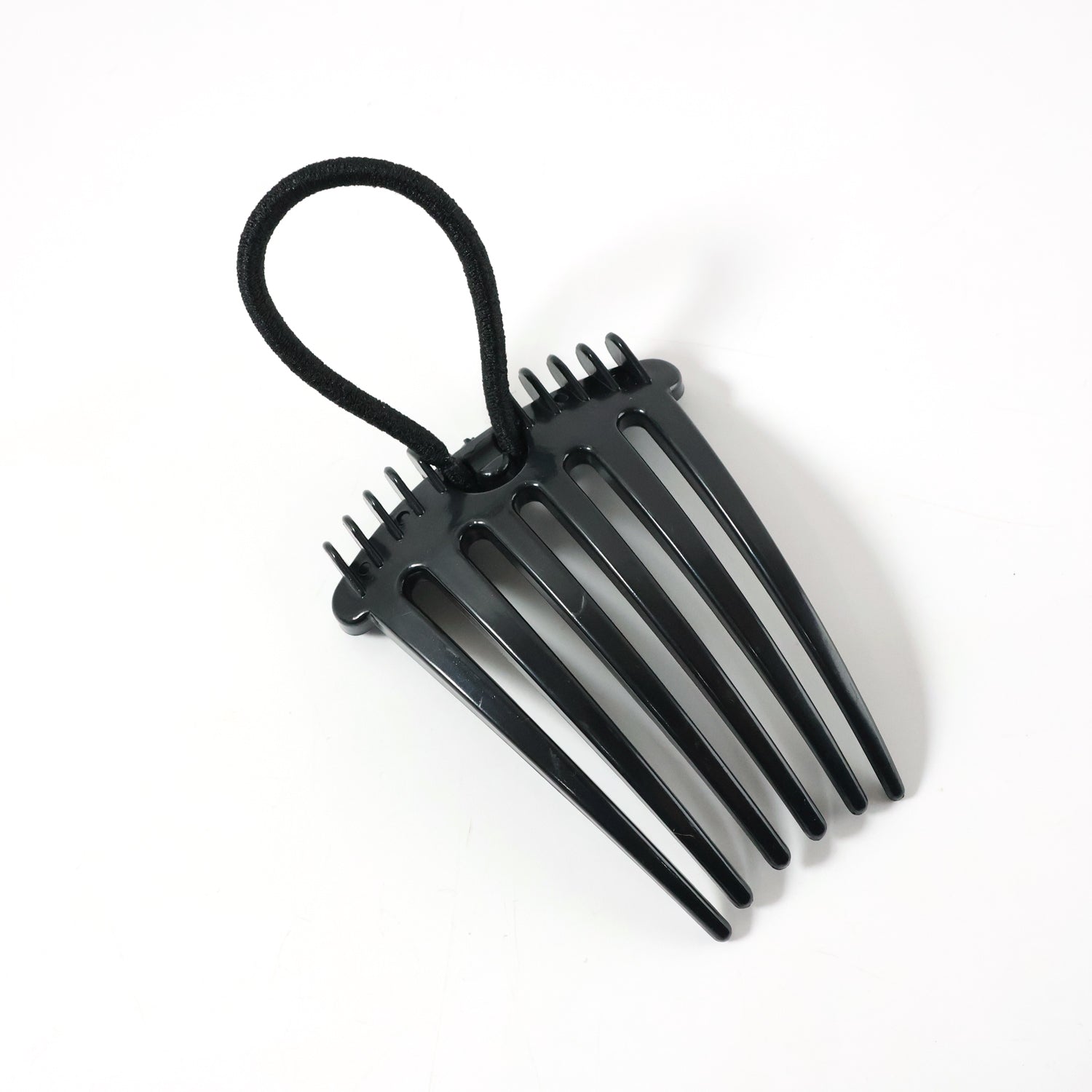 Hair styling comb clip securing hair in a voluminous bun style