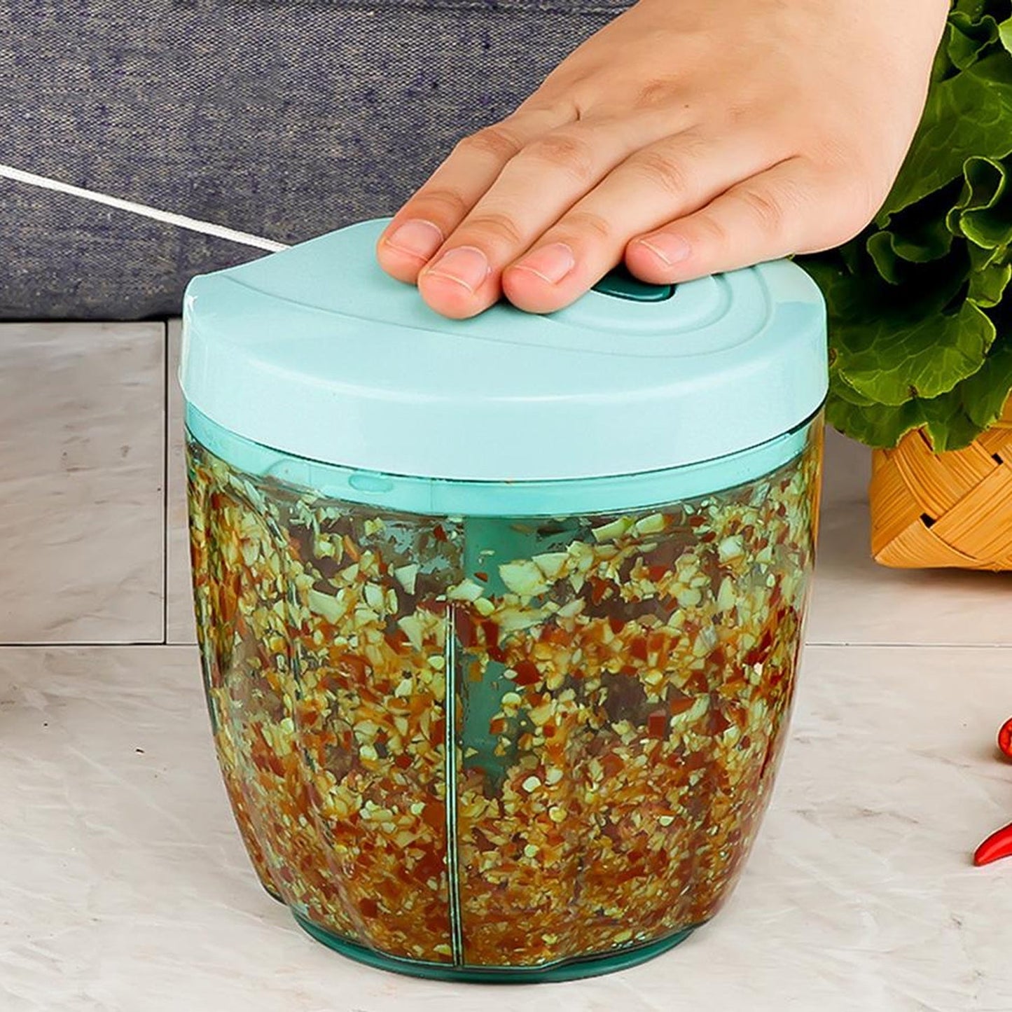 Teal manual pull-string food chopper equipped with 5 extra sharp stainless steel blades.