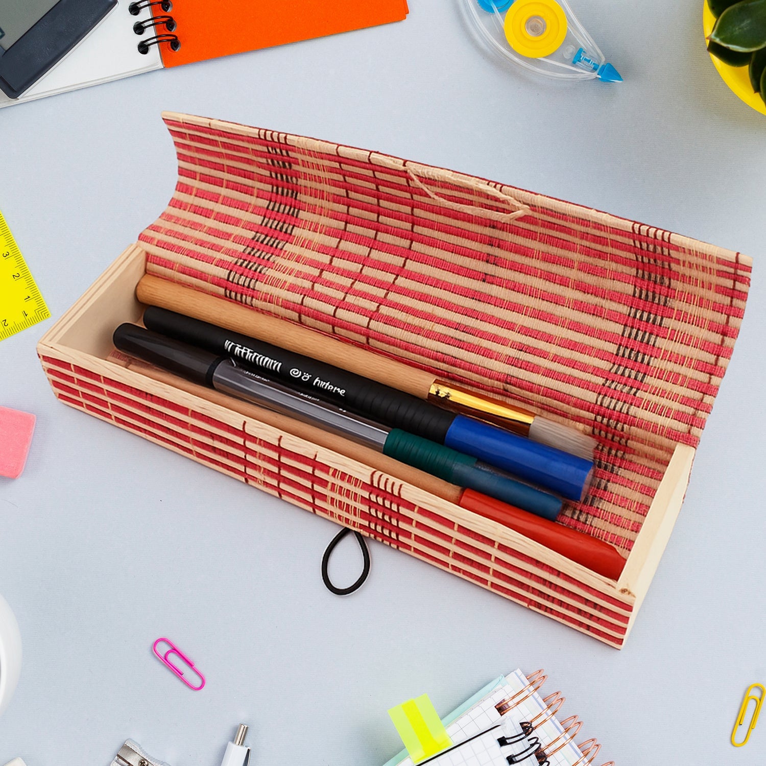 Handcrafted bamboo mat style pen and pencil box on a wooden surface