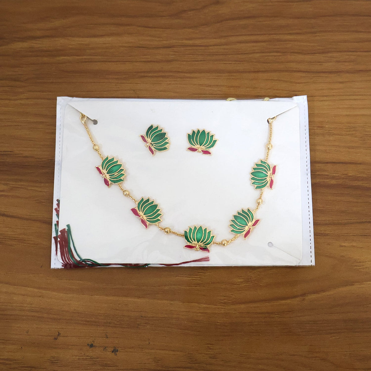 Elegant ethnic jewellery set with green lotus motifs and gold finish