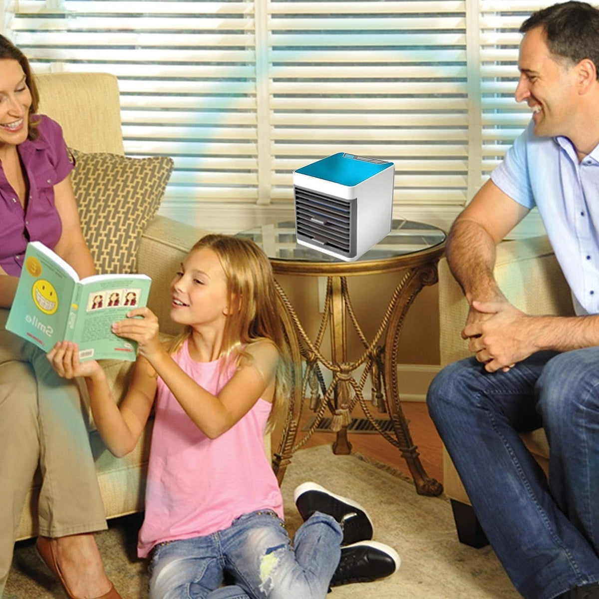 A family sitting in a living room with a portable air cooler on a glass table between them, emitting cool air.
