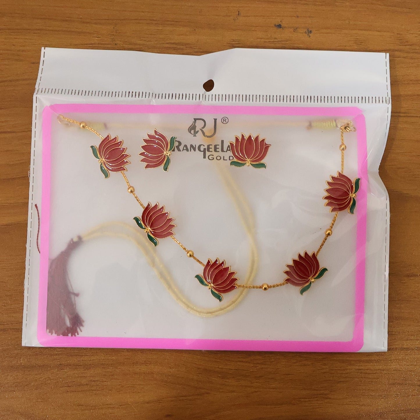 Red lotus necklace set displayed with matching earrings for festive wear