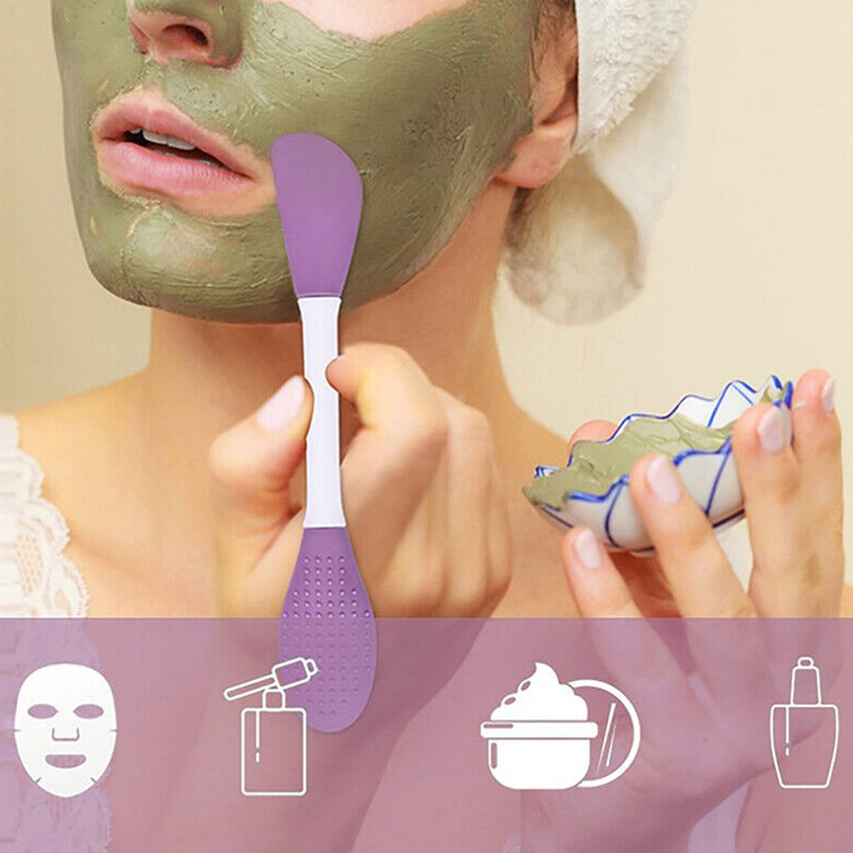 A woman with a green face mask applying it with a purple and white double-headed silicone brush, holding a bowl of mask.
