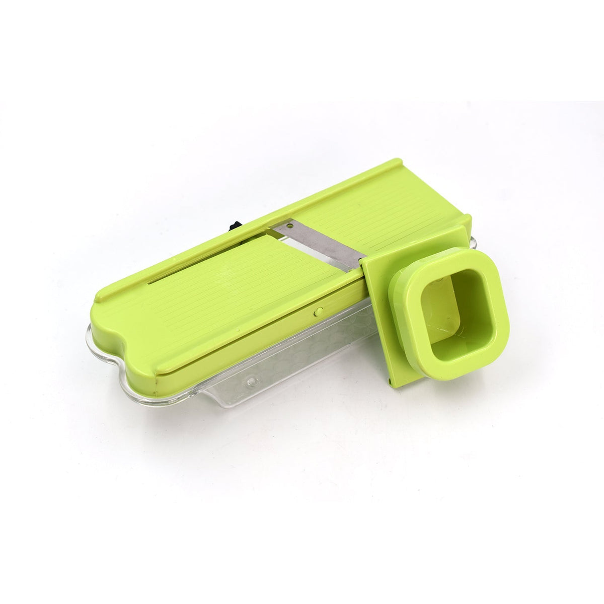 A light green plastic slicer with a clear base and a square chute is angled on a white background.