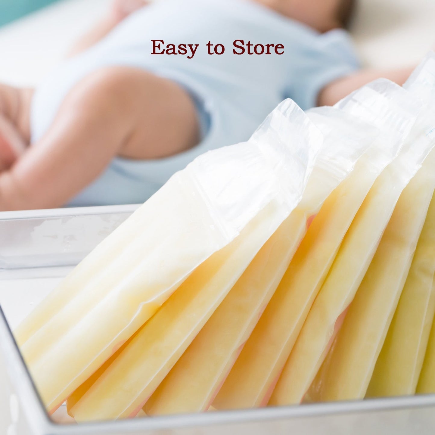 Breastmilk storage bags filled with frozen milk are neatly stored in a container, with a baby in the background.