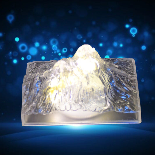 A clear plastic Iceberg Night Light illuminating a dark room, showcasing its unique design.