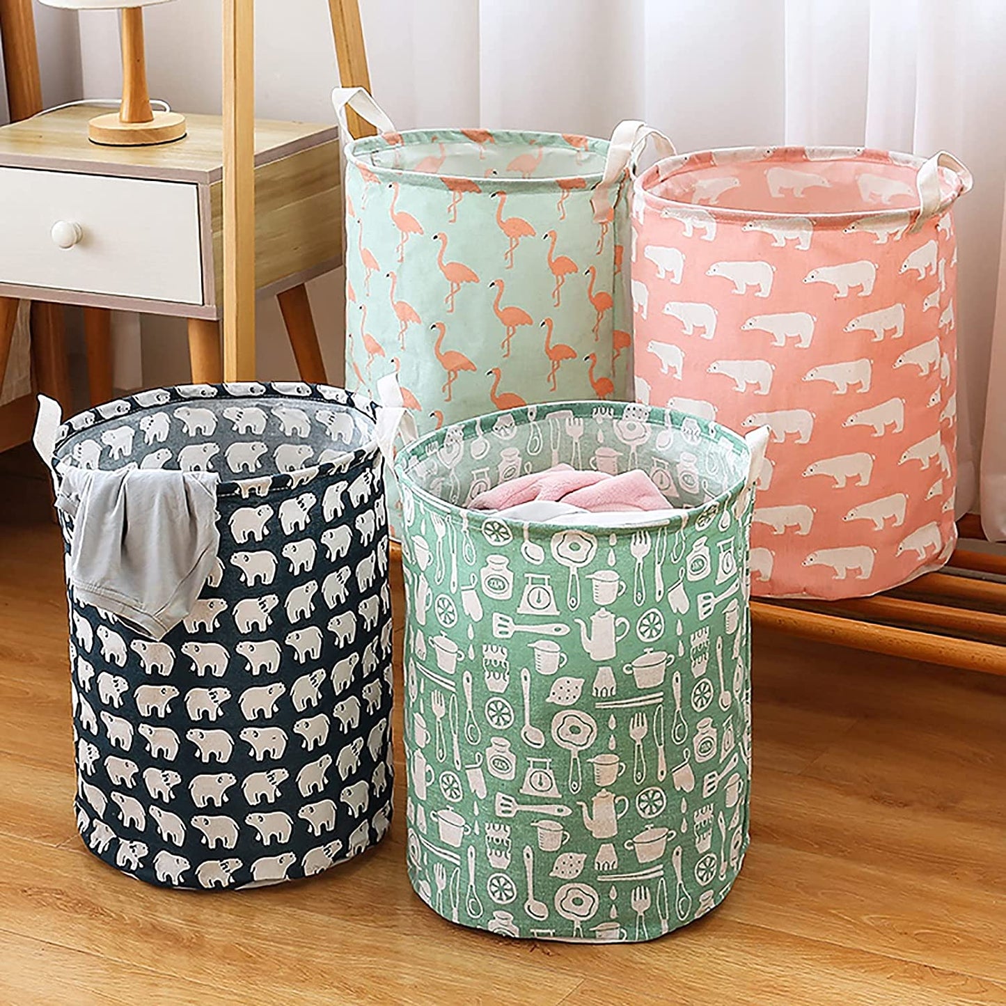 Four fabric laundry hampers with different patterns: polar bears, flamingos, and kitchen utensils.
