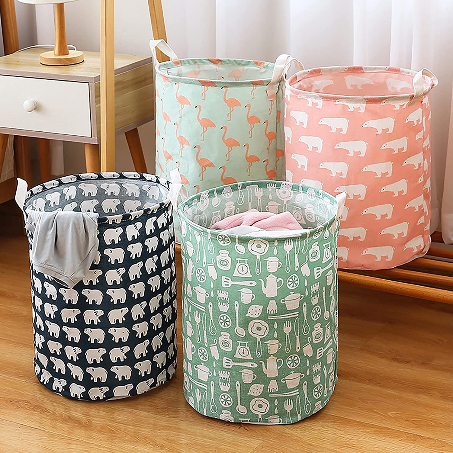 Four fabric laundry hampers with different patterns: polar bears, flamingos, and kitchen utensils.