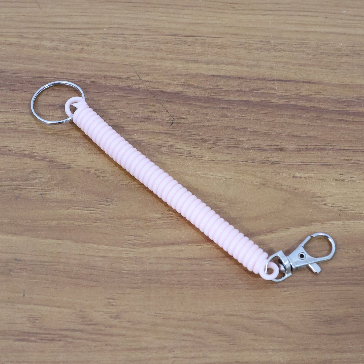 Side angle of elastic spiral coil keychain bracelet highlighting coil flexibility