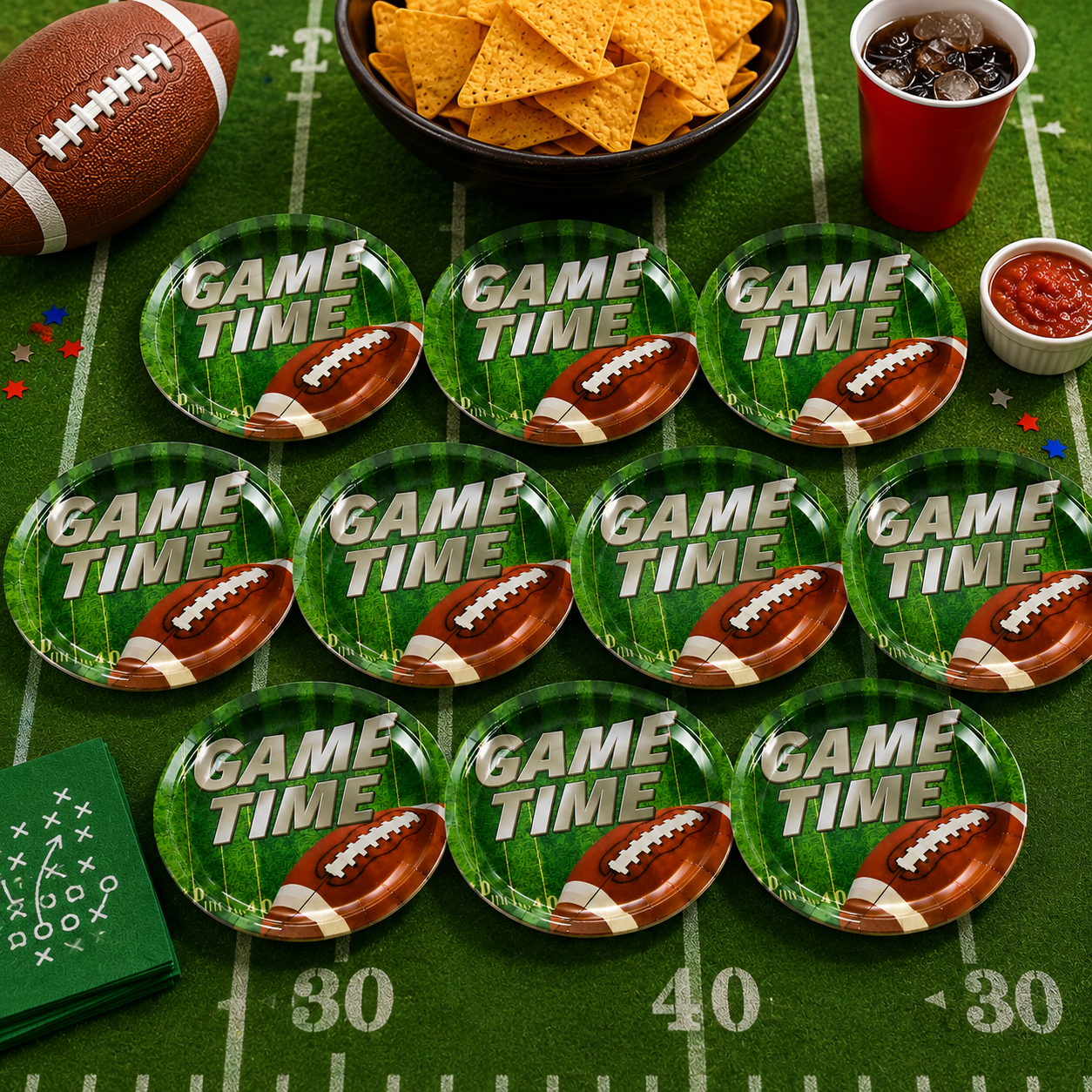 Ten green paper plates with a football and 'GAME TIME' text, surrounded by football-themed party items.