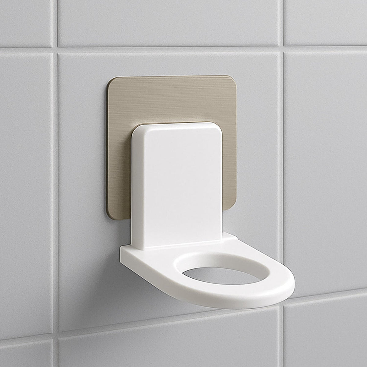 A white plastic wall-mounted bottle holder with a metallic adhesive backing on a white tiled wall.