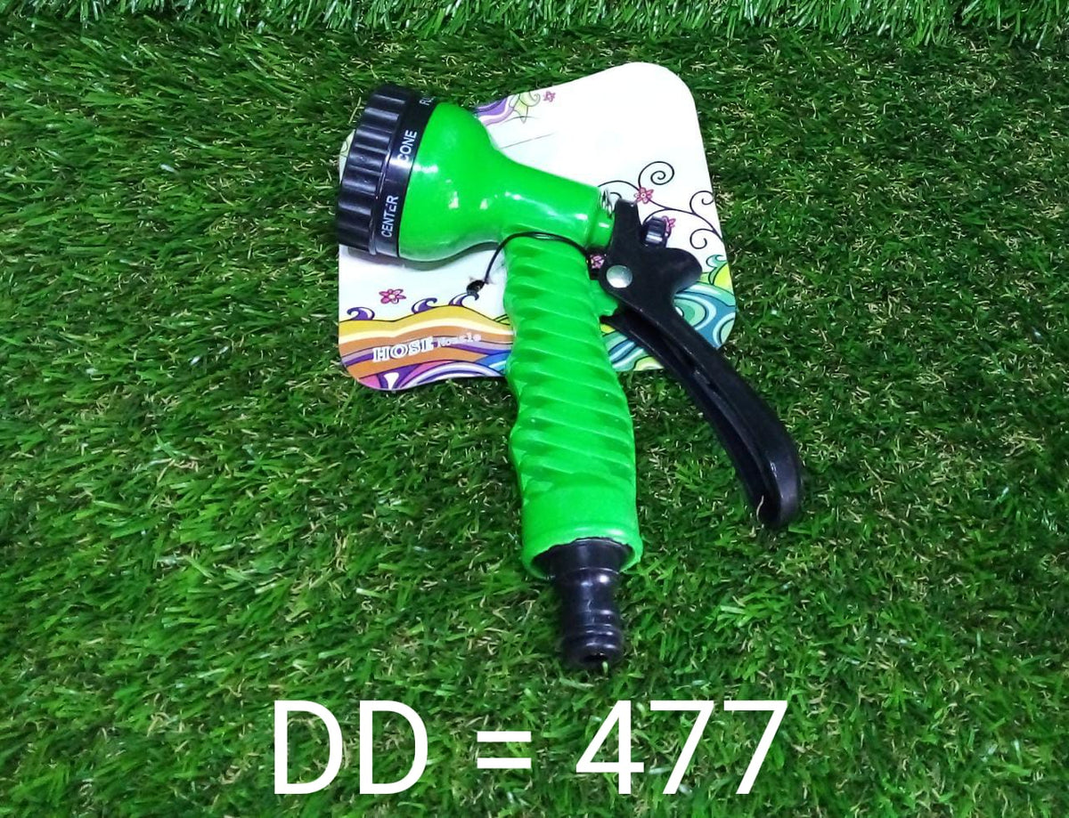 A green and black hose nozzle with decorative packaging rests on artificial green grass.