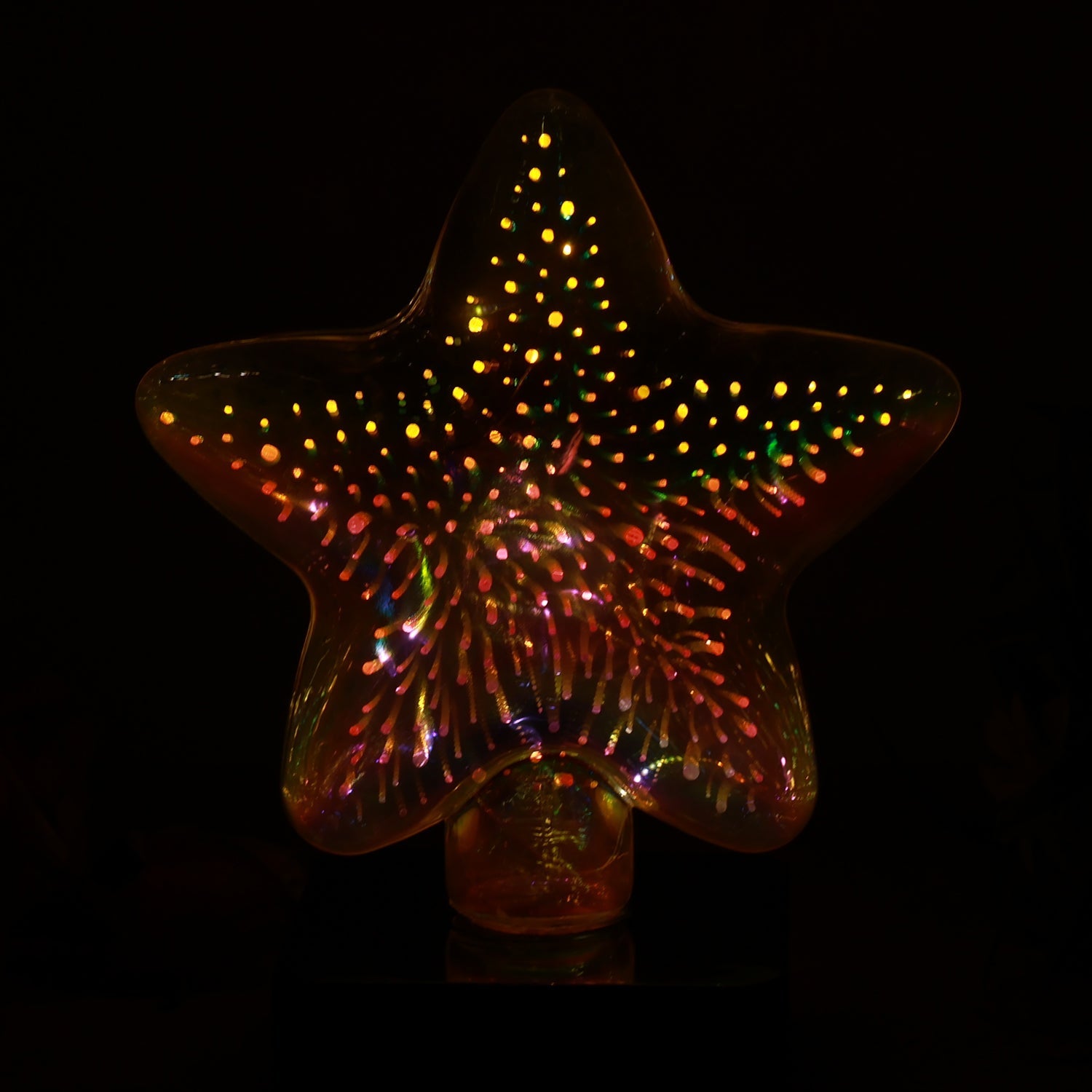 Star shape 3D illusion night lamp illuminating vibrant colors in a dark room